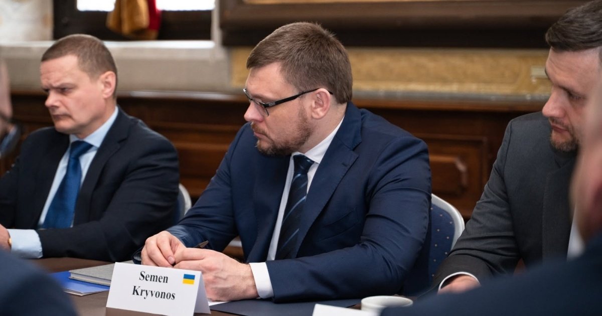 Руслан Кравченко, генеральний прокурор України, стоїть за трибуною та виступає перед мікрофонами