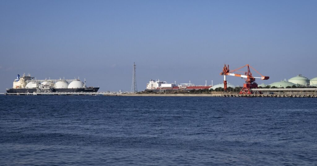 Торгове судно проходить через Ормузьку протоку на тлі військових кораблів.